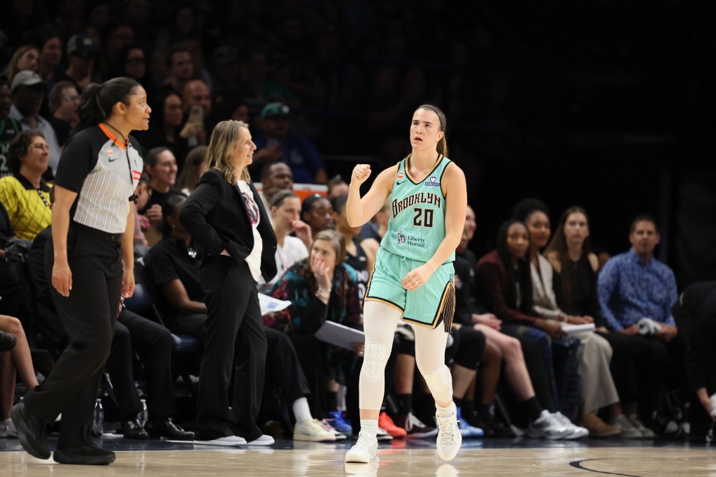 Sabrina Ionescu pumps her fist while walking by Lynx head coach Cheryl Reeve