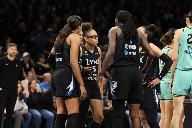 The Lynx wearing their all black uniforms gather in a huddle