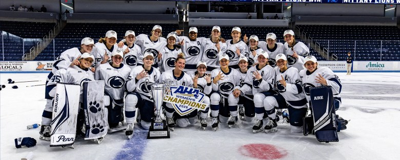 Penn State’s women’s ice hockey team celebrates at center ice with the AHA championship trophy.