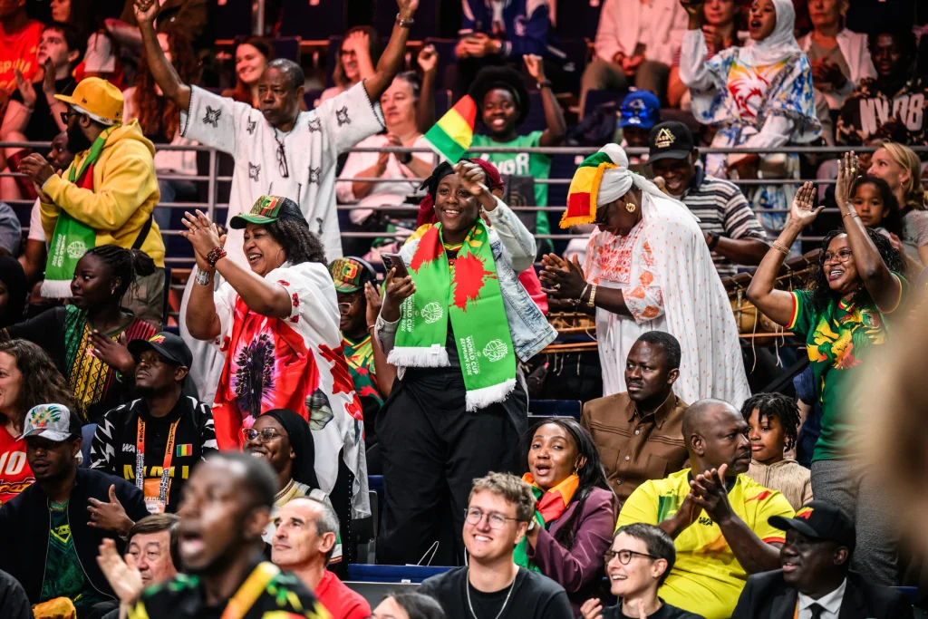 Mali fans celebrate as a balafon player plays his balafon in the background