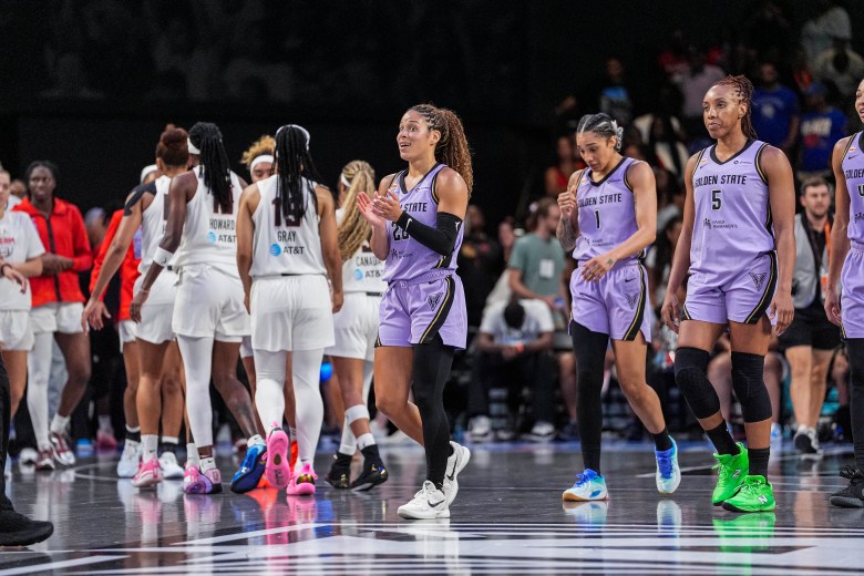 Veronica Burton leads her Valkyries teammates past the Atlanta Dream huddle.