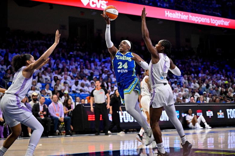 Arike Ogunbowale jumps for a right-handed layup in front of defender Kaila Charles.
