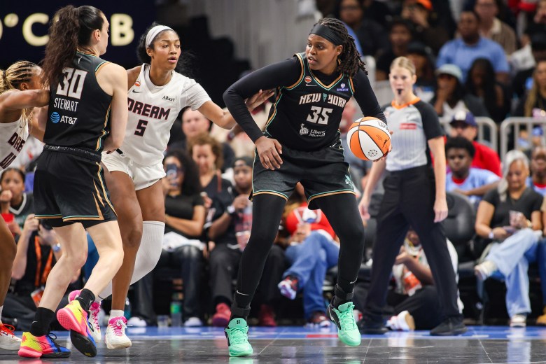 Jonquel Jones holds the ball while being guarded by Angel Reese. Breanna Stewart looks to set a screen for Jones.