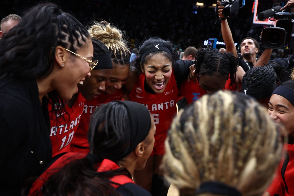 Angel Reese cheers during a huddle with her Atlanta Dream teammates
