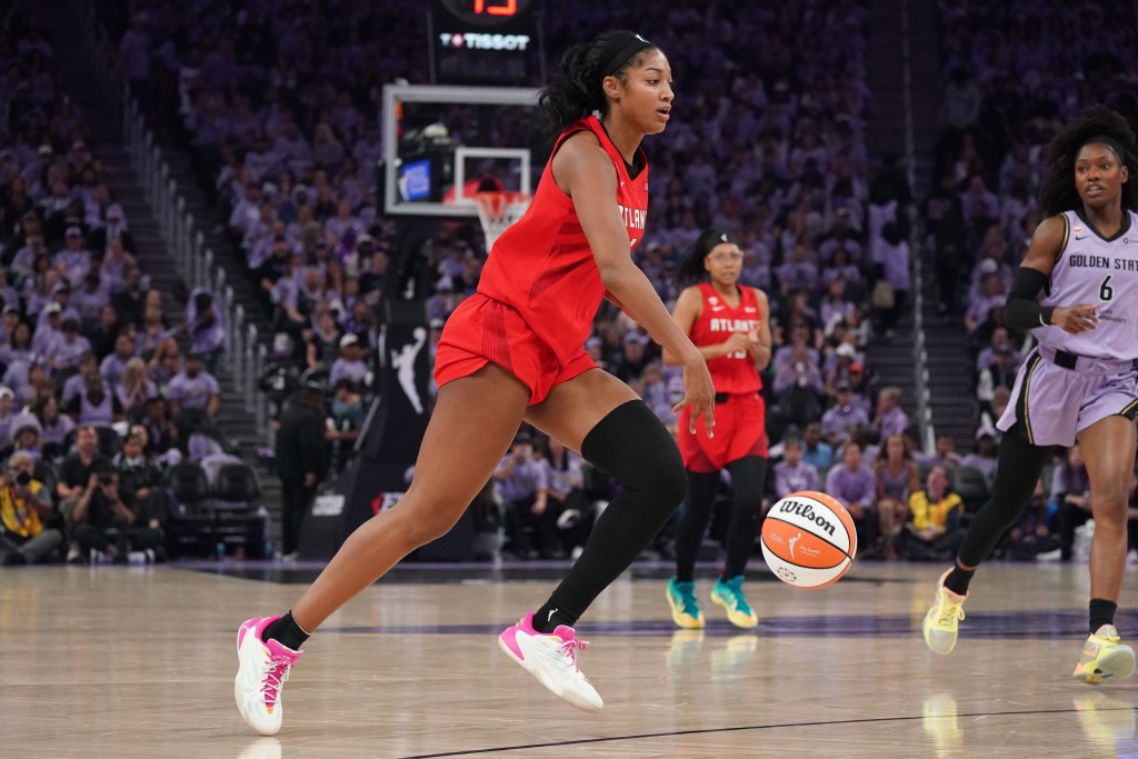 Angel Reese dribbles.