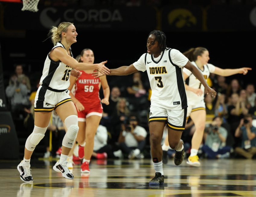 Iowa guard Amari Whiting smiles as she slaps hands with teammate Dani Carnegie after a made shot.