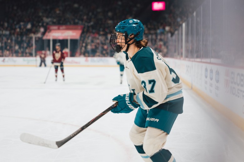 A women's hockey player skates on the ice.