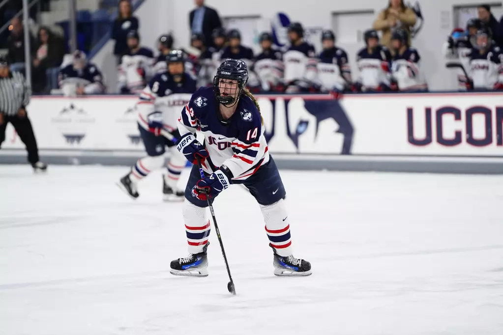 A women's hockey player handles the puck.