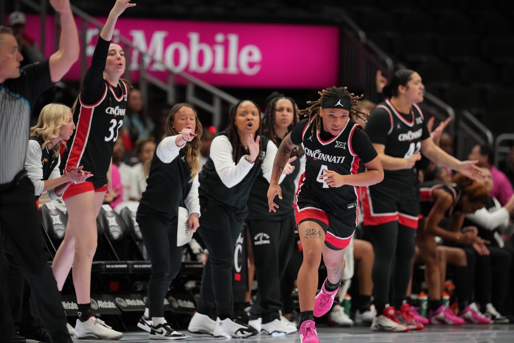 The Cincinnati women's basketball team bench erupts after a play made by guard <a rel=