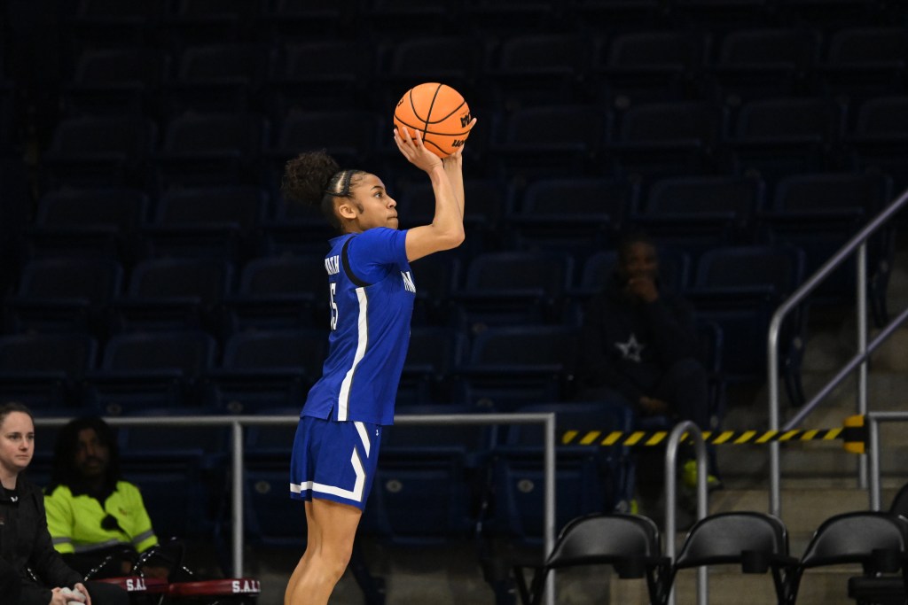 A player in a blue jersey prepares to shoot a basketball.