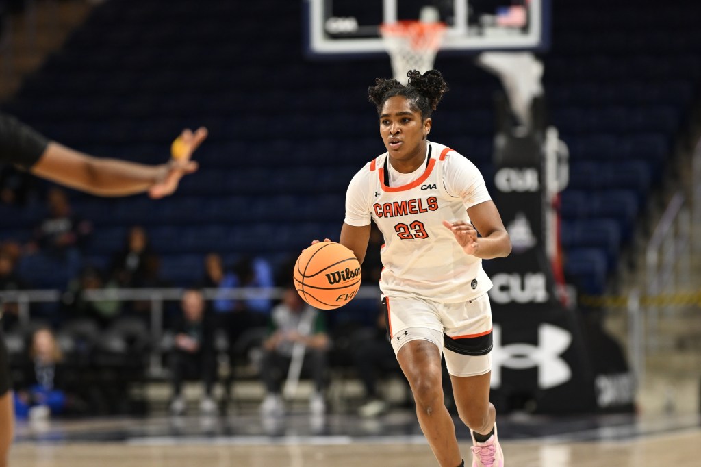 Jasmne Felton in a white shirt dribbles the ball.