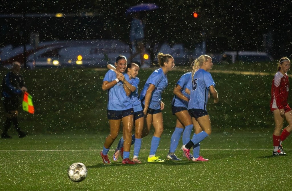 Johnson County Community College players celebrate a goal scored by Flo Rigby.