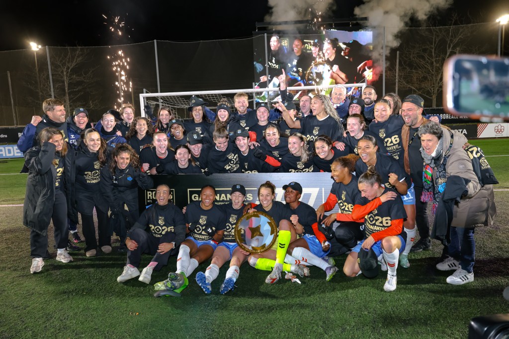 Players in black shirts hold the NSL Supporters' Shield.