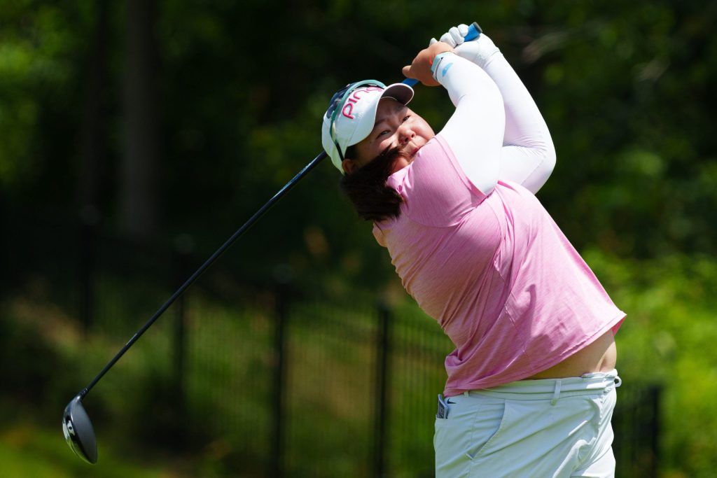 Mirabel Ting tees off and looks toward the right.