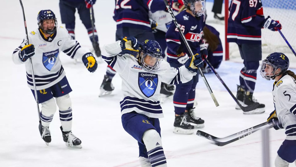 A women's hockey player celebrates a goal.